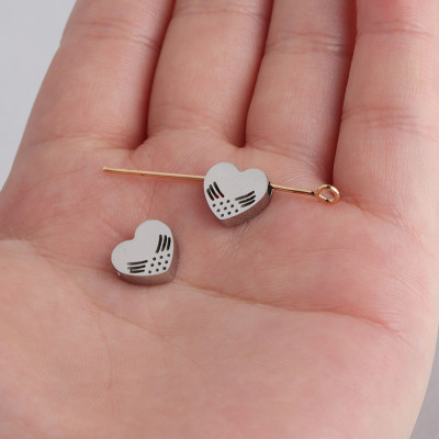 Bead with a small heart through with surgical steel wings